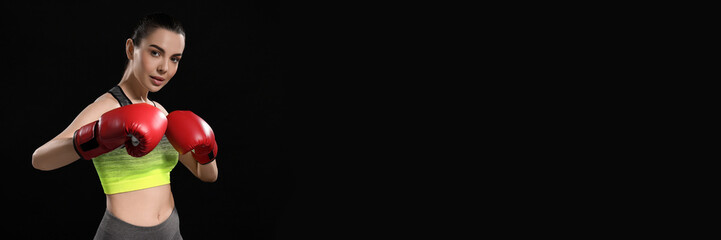 Beautiful woman in boxing gloves training on black background. Banner design with space for text