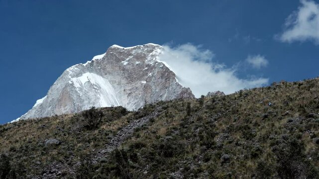 Huascaran in Peru Cordillera Blanca Wide shot time lapse white fluffy clouds in blue sky above snowy mountains