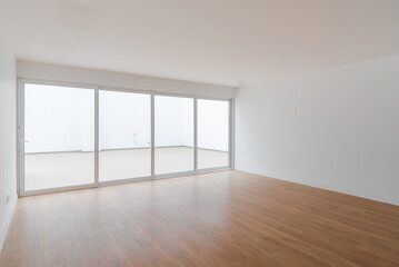 Sala de departamento vacio con piso laminado y ventana con vista a la calle