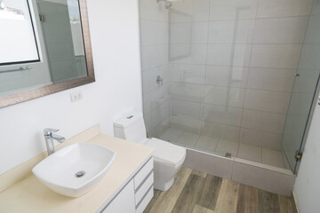 baño de departamento con acabados de loza , lavabo inodoro y ducha con tina