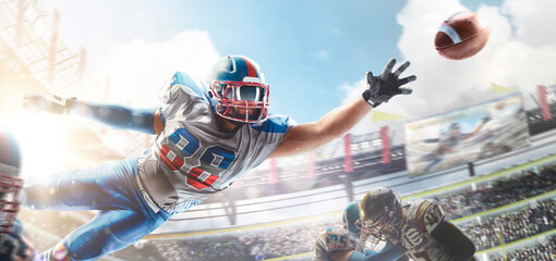 American football. Sportsman in action. Player catches the ball and flies in the air. Sports arena with fans. Bright sun. Front view