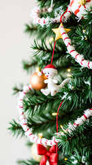 snowman ornament hanging on a decorated christmas tree