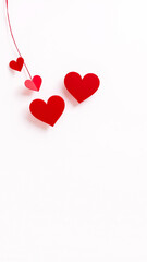 red paper hearts hanging on a white background