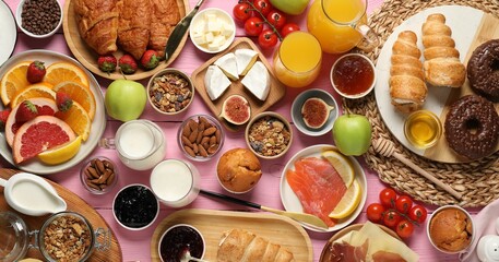 Different tasty food served for brunch on pink wooden table, flat lay