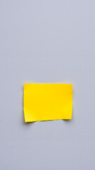 single torn yellow paper on a gray background