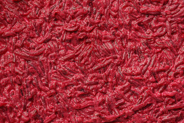 Close-up of a red textured abstract background with various fragments scattered across the surface.