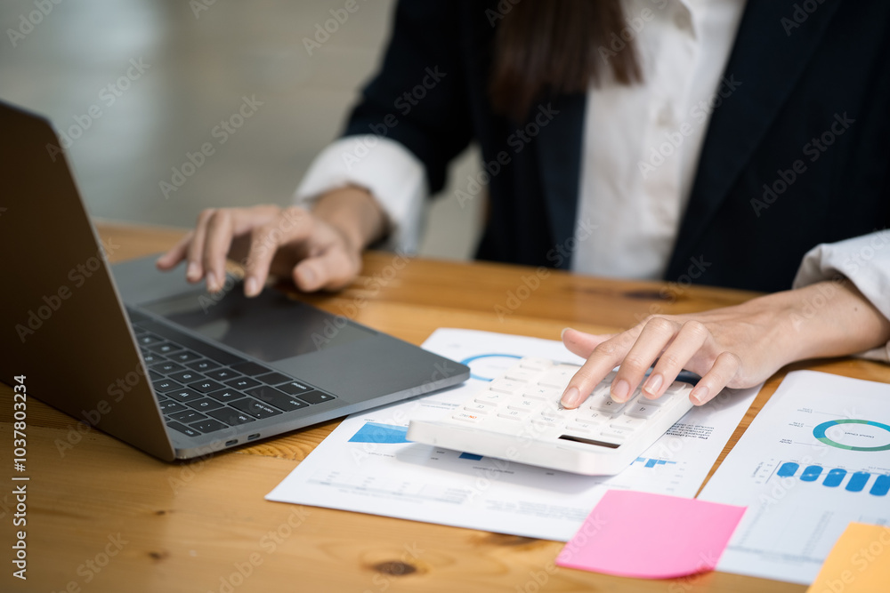 Poster close up of hands typing on laptop keyboard and working on document paperwork and calculator for cos