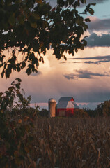 Sunset Over Red Barn and Silo in the Countryside.