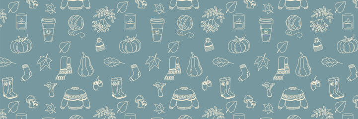 Hand drawn fall patterns on blue background, seamless template. Scarf, candle, hot coffee, tea, socks, sweater, scarf and hat, ball of wool thread, leaves, berries, acorns and mushrooms. Cozy fall