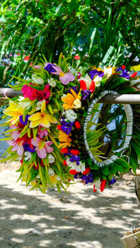 Polynesian cultural lei of beautiful colourful flowers at market stall on the tropical island of Mo'orea in French Polynesia, South Pacific