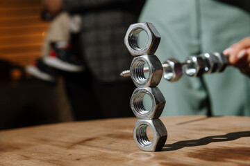 A person is meticulously stacking nuts on top of one another skillfully on a wellcrafted wooden...
