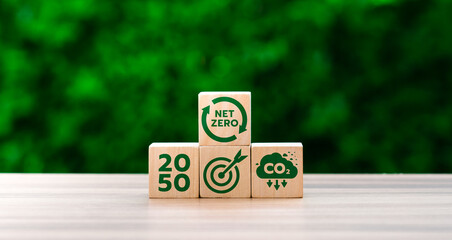 Wooden Blocks Displaying Net Zero, CO2 Emission Reduction, and 2050 Target Goals Against Green Background, Representing Climate Action and Sustainability Milestones