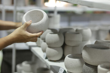 A man's hand is picking up a pot for planting a tree. Small plant pots are suitable for planting small plants.