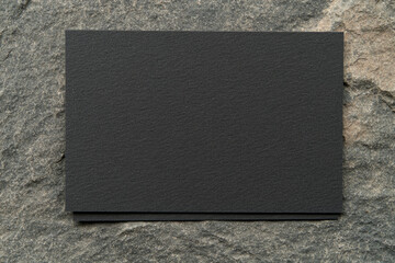 Fototapeta premium A black card with a white border sits on a rock