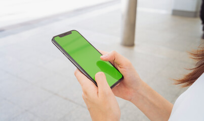Hand holding smartphone mockup of green screen, Take your screen to put on advertising.