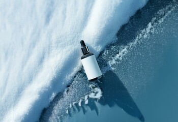 A frosted glass bottle with a dropper lies on a surface partially covered in snow.