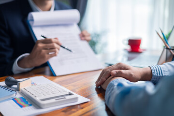 Businesswoman reviewed mortgage document and contract with their client, ensuring loan and credit...