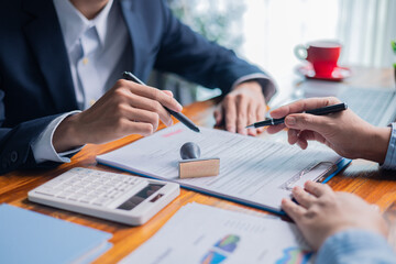 Businesswoman reviewed mortgage document and contract with their client, ensuring loan and credit...