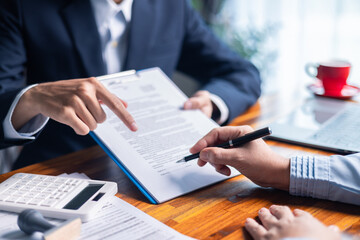 Businesswoman reviewed mortgage document and contract with their client, ensuring loan and credit...