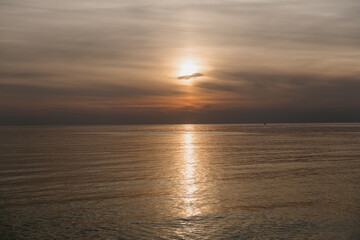 As the sun makes its descent beyond the horizon, its warm light is beautifully reflected on the...