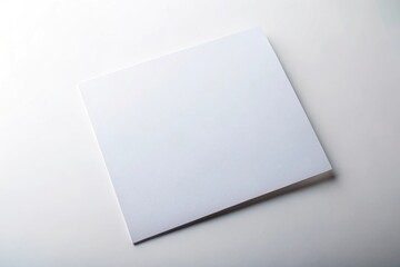 blank white rectangle sheet of paper on clean white background tilted angle