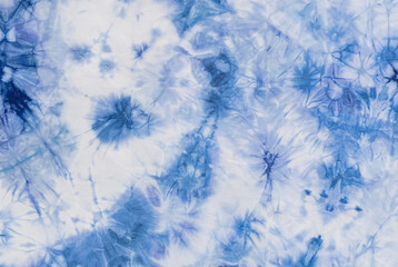 Blue and white tie-dye fabric texture with abstract patterns, perfect for backgrounds or textile...