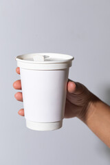 hand holding a paper cup of coffee 12 oz.