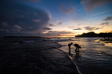 children playing in the water at sunset 
