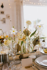 A beautifully arranged table featuring plates, glasses, candles, and lovely flowers elegantly placed upon its surface