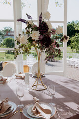 A beautifully arranged table set for a wedding reception, adorned with an elegant vase filled with vibrant flowers on its surface