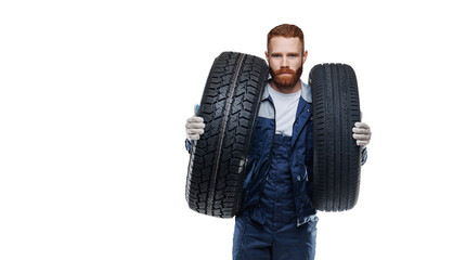 Auto mechanic hold two car tires on isolated white background with copy space © Parilov