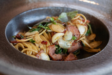 Spaghetti aglio e olio; Traditional Italian pasta with dried chili, garlic, olive oil and crispy bacon flakes on top. Top view