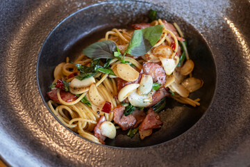 Spaghetti aglio e olio; Traditional Italian pasta with dried chili, garlic, olive oil and crispy bacon flakes on top. Top view