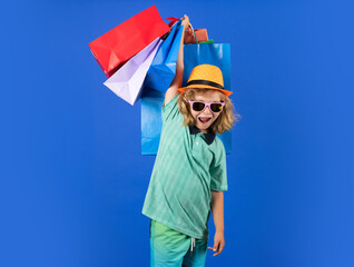 Fashion kid with shopping bag in studio. Little shopper child.