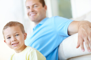 Boy, dad and relax on sofa in home for portrait, bonding and love with smile for connection in morning. Child, father and happy man for security, playful and care in lounge at family house in France