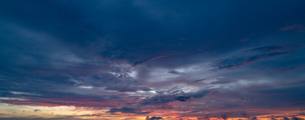 Fototapeta premium Sunrise background. Dramatic majestic scenery sunset. Sky with clouds in Sunrise sky light background. Sunrise with clouds in various shapes. Calm Sunrise sky and sun through clouds over.