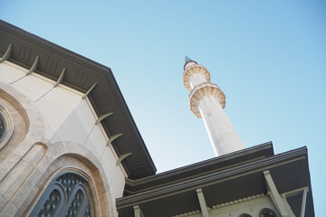 A beautiful mosque featuring a stunning minaret prominently showcased against a clear blue sky