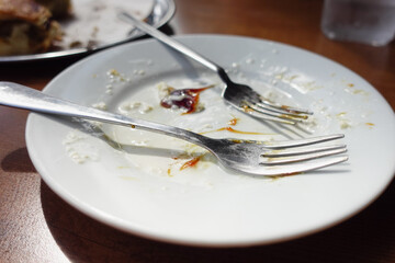 An empty plate with a spoon rests after a delicious, satisfying meal has been enjoyed