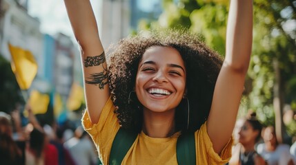 A woman with a tattoo on her arm is smiling and holding a yellow sign
