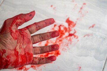 A bloody palm lying in a pool of blood on a dark floor, symbolizing violence and trauma