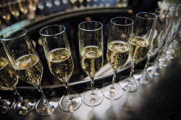 A beautiful and elegant bunch of champagne glasses is meticulously lined up on a stylish table ready for a delightful gathering occasion