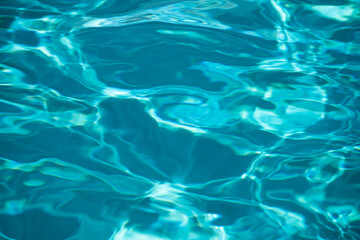 Ripple Water in swimming pool with sun reflection. Wavy water background.