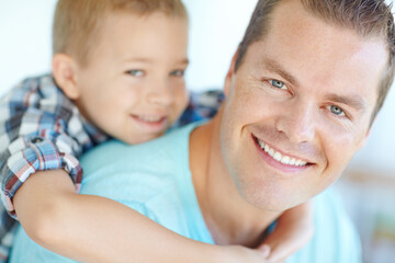Portrait, piggy back and father with boy, smile and bonding together with happiness in lounge. Family, single parent and dad carrying son, cheerful and childhood with fun, playful and game in house