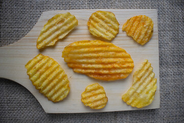 Potato chips on wooden cutting board
