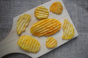 Potato chips on wooden cutting board