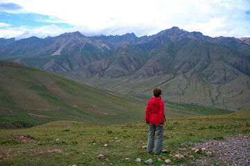 Fototapeta premium Rear view of senior woman hiking in Kyrgyzstan mountains