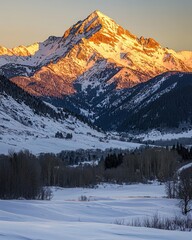 Obraz premium Snowy Mountain Peaks at Sunrise with Warm Light