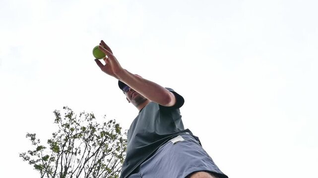 Low angle view of man practicing tennis in park outdoors