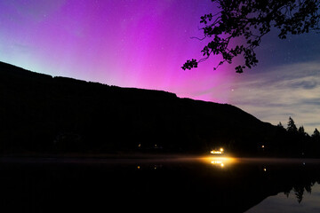 Purple Aurora Borealis above homes