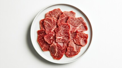 A top-down view of thinly sliced beef arranged on a white plate against a white background, ideal for dishes like carpaccio or stir-fry.